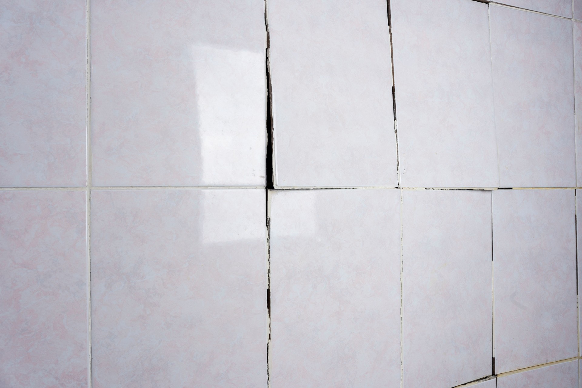 Old cracked tile in the bathroom, Cracked tile on the bathroom wall needs repair. Construction problems